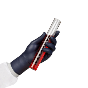A person's arm in PPE with a black nitrile glove holding a testube with red liquid.